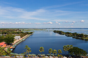Fototapeta na wymiar Nong Han Sakon Nakhon View Point High angle. Fresh green trees on the banks of the river and clear sky. Cycling paths on the river and sightseeing jetty.