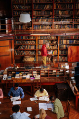 Professor in library with students.