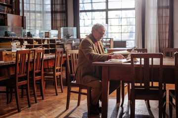 University professor working in library.