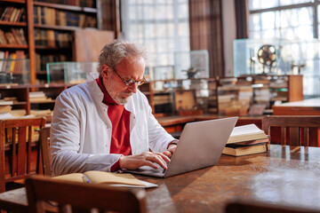 Medical professor working in library.