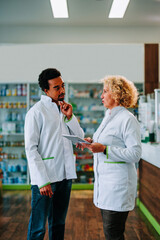 Obraz premium Diverse pharmacists using digital tablet in pharmacy.