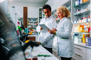 Diverse pharmacists working at counter.