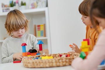 Kindergarten children playing with colorful building blocks. Healthy learning environment. Learning through play.