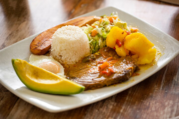 Cooked posta, with rice, salad, and avocado - Traditional Colombian dish - obrazy, fototapety, plakaty