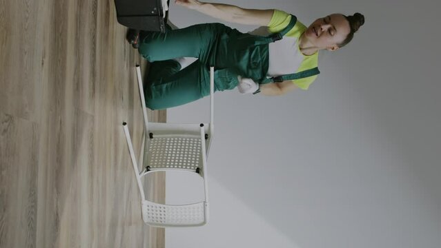 Female is assembling a chair. Vertical video