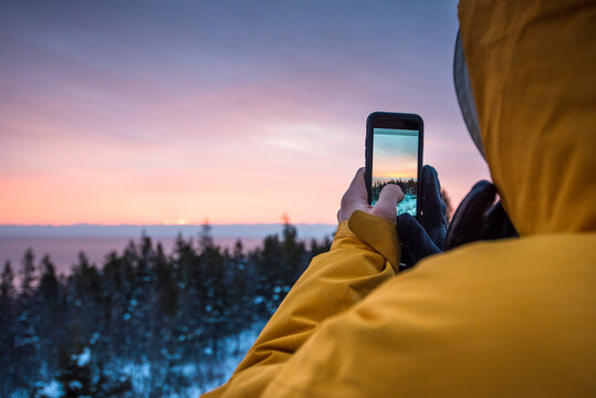 Man taking picture with smartphone, Acadia National Park, Maine, USA