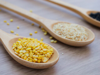 Yellow sesame seed on wooden spoon, concept of healthy food.