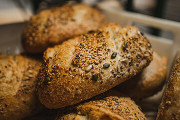 Close up shot of several stacked seed breads in a box in a bakery