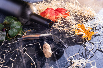 Sommelier knife with wine stopper on an old table with shavings and yellow leaves. Autumn and...