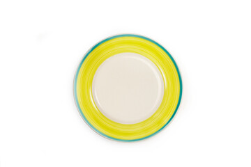 Plato redondo blanco con borde amarillo y azul sobre un fondo blanco liso y aislado. Vista superior...