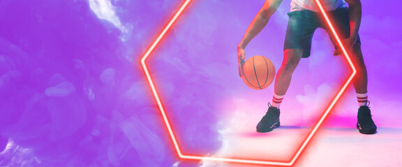 Low section of biracial basketball player dribbling ball by hexagon over smoky background - Powered by Adobe