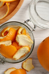 Orange peels preparing for drying and fresh fruit on white wooden table, flat lay