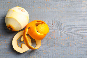 Peeled fresh orange with zest preparing for drying on wooden table, flat lay. Space for text