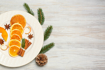 Flat lay composition with dry orange slices, anise stars, cinnamon sticks and fir branches on white wooden table, flat lay. Space for text