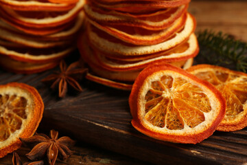 Dry orange slices and anise stars on wooden board, closeup
