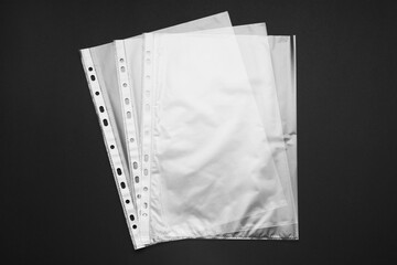 Punched pockets on black background, flat lay