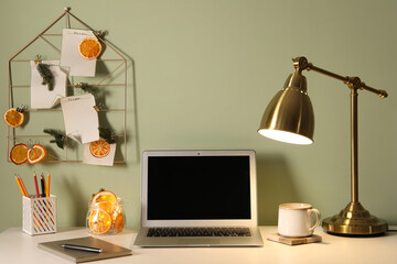 Stylish workplace with handmade decor made of dry orange slices and notes