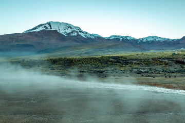 Geysers El Tatio with river and volcanic landscape at sunrise, Atacama, Chile