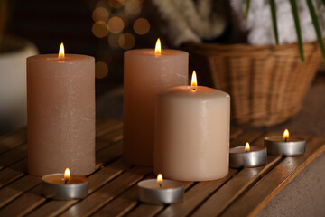 Spa composition with burning candles on massage table in wellness canter