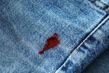 Stain of red ink on jeans, closeup