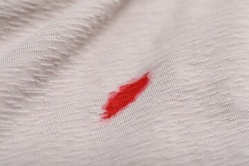 Stain of red ink on beige shirt, closeup