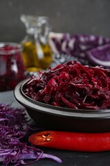 Tasty red cabbage sauerkraut and ingredients on grey table, closeup