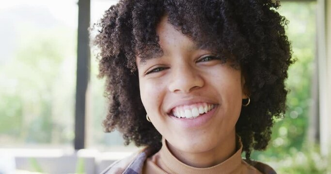 Portrait of happy african american teenage girl, smiling and laughing, slow motion