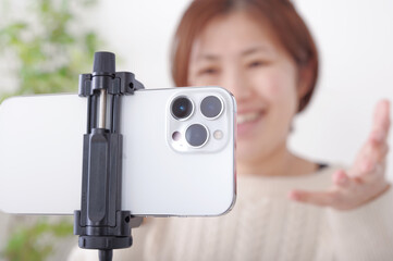 Naklejka premium 固定されたスマホに向かってしゃべる女性