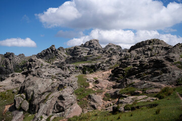 Panoramic view of the rock massif Los Gigantes in Cordoba, Argentina, under a blue sky with clouds. 