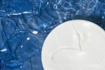 Cosmetic cream. White in a jar. Against the background of water and glass.
