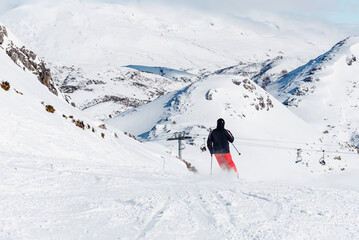 Fototapeta na wymiar Unrecognizable person skies down a snowy mountain on a ski slope. winter sports. 