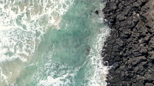 Sea and volcanic rocks close-up aerial view, natural background.