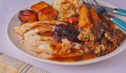 Traditional roast chicken dinner with all the trimmings and garnished with cranberry sauce.