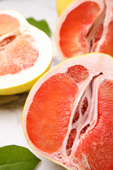 Different tasty pomelo fruits on white marble table, closeup