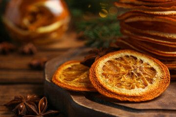 Dry orange slices and anise stars on wooden table, closeup. Space for text