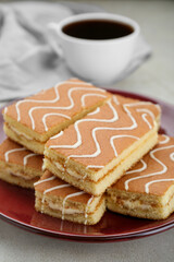 Tasty sponge cakes and hot drink on light grey table, closeup