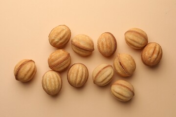 Homemade walnut shaped cookies with condensed milk on beige background, flat lay