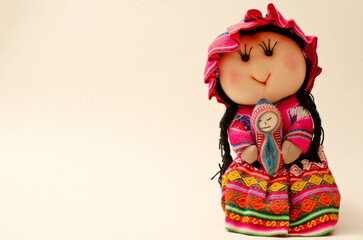 Peruvian doll in white background. Mother carrying her baby and wearing a traditional dress 