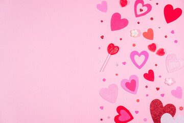 Valentine’s Day. Pink background with red and pink hearts, sweets of heart and sparkles. 