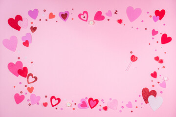 Valentine’s Day. Pink background with red and pink hearts, sweets of heart and sparkles. 