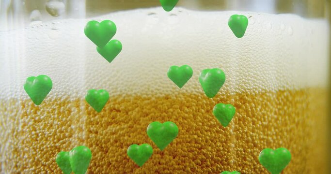Animation of st patrick's day green hearts on glass with beer background