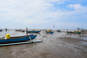 Fototapeta na wymiar Fishing boat on the beach with blue sky background in Indonesia