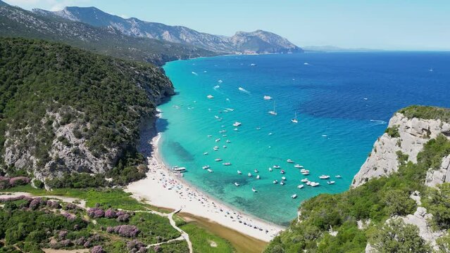 Boats and Tourists at Cala Luna Beach, Baunei Coast, Sardinia, Italy - Aerial 4k Dolly