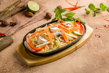 wok udon noodles with vegetables, vegetarian wok on brown table