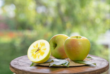 Green Meigetsu apple in the basket over green natural Blur background, Fresh Green Honey core Apple in wooden basket.