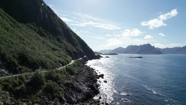 Low aerial forwarding shot of a famous Norwegian coastal road to a old fishing village