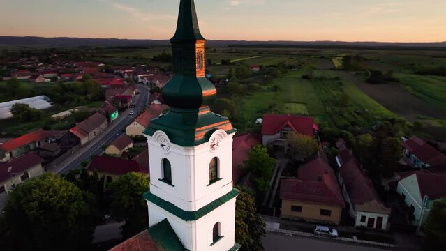 Aerial orbit view of reformed protestant church clock tower at sunset