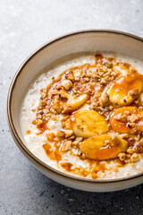 Oatmeal porridge with banana and almonds macro close up vertical
