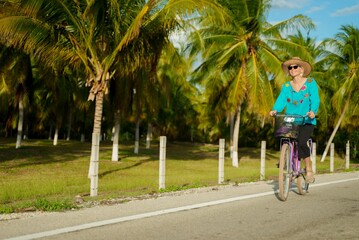 Front view of happy smiling pretty mature senior woman smiling biking towards the camera wearing...