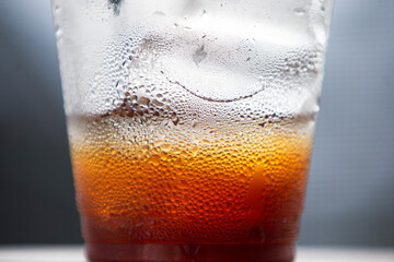Cold cola with ice cubes in a glass on a dark background